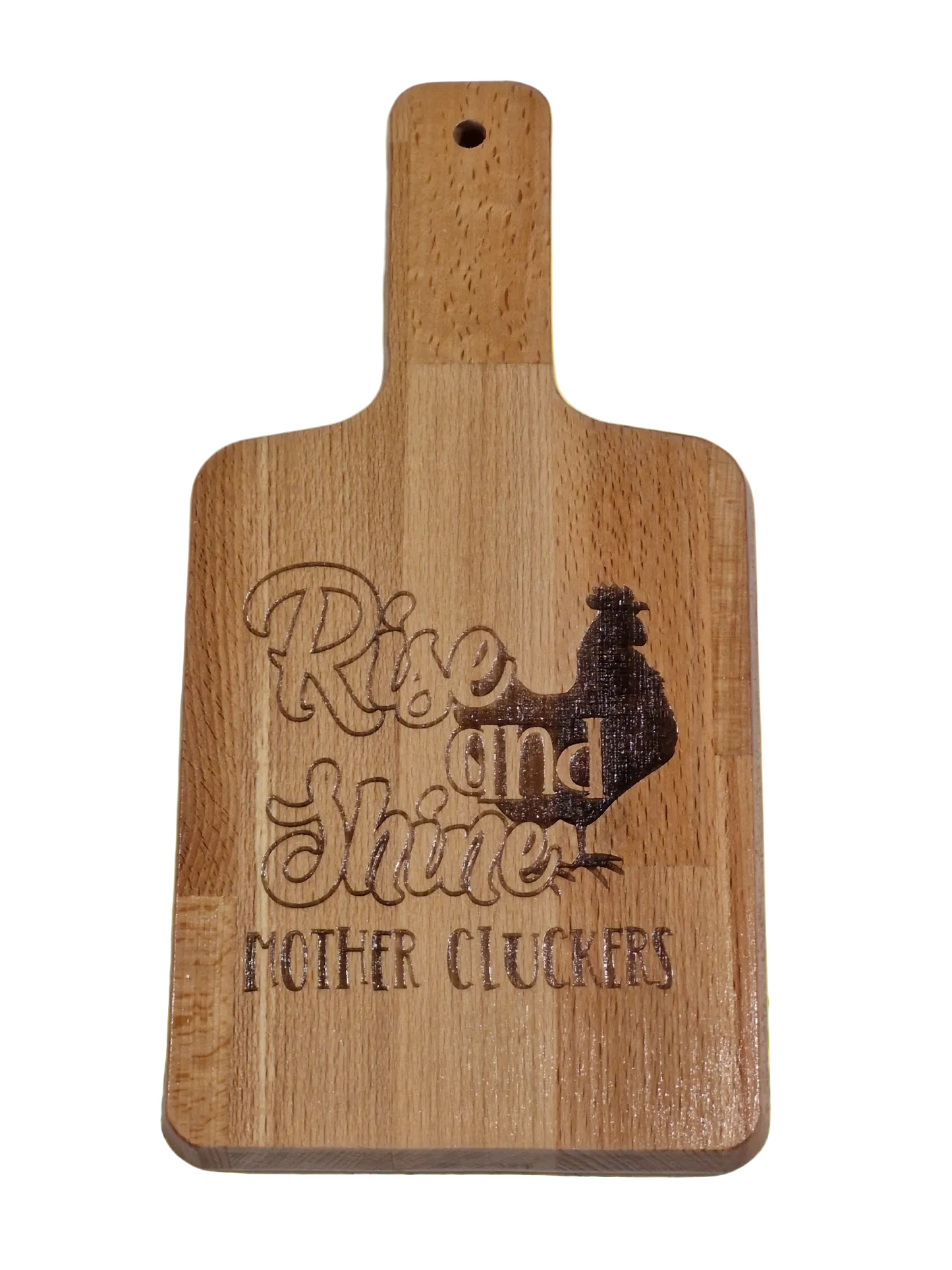 A wooden serving board with an engraving of a rooster and the phrase 'Rise and Shine Mothercluckers' printed on it, placed on a white background.