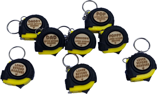 Set of eight retractable tape measures with keychains on a white background