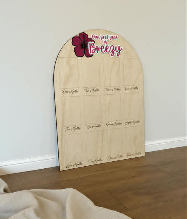 Wooden board with floral design and text on a wooden surface against a white wall