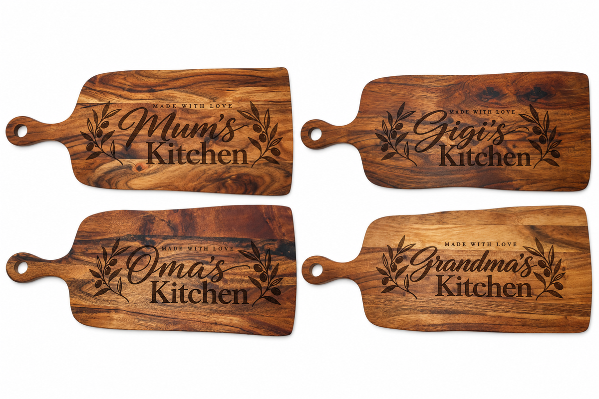 Personalised acacia wood serving boards featuring Mum's Kitchen, Gigi's Kitchen, Oma's Kitchen and Grandma's Kitchen engravings with botanical olive branch designs, displayed together on a white background.