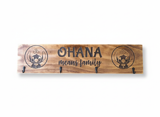 Timber wall key holder engraved with the Ohana Means Family quote and fitted with four black hooks for keys and everyday essentials.