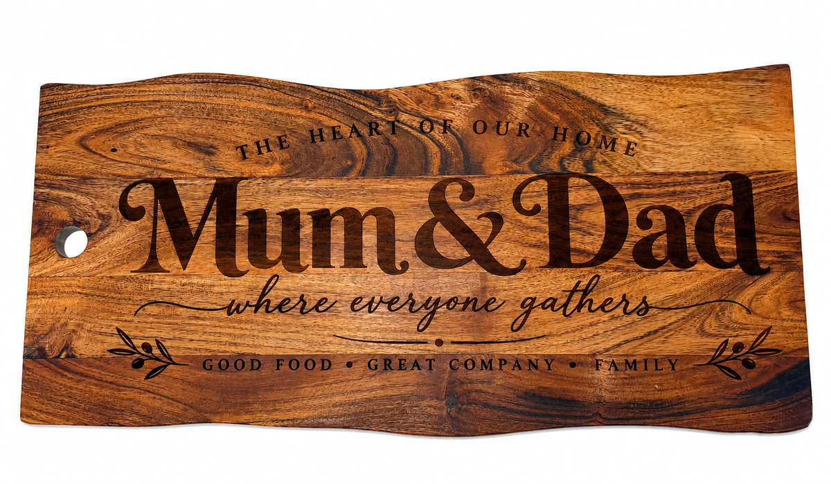 Large engraved Mum & Dad acacia wood serving board with rustic natural edges, decorative lettering and botanical flourishes, photographed on a plain white background.