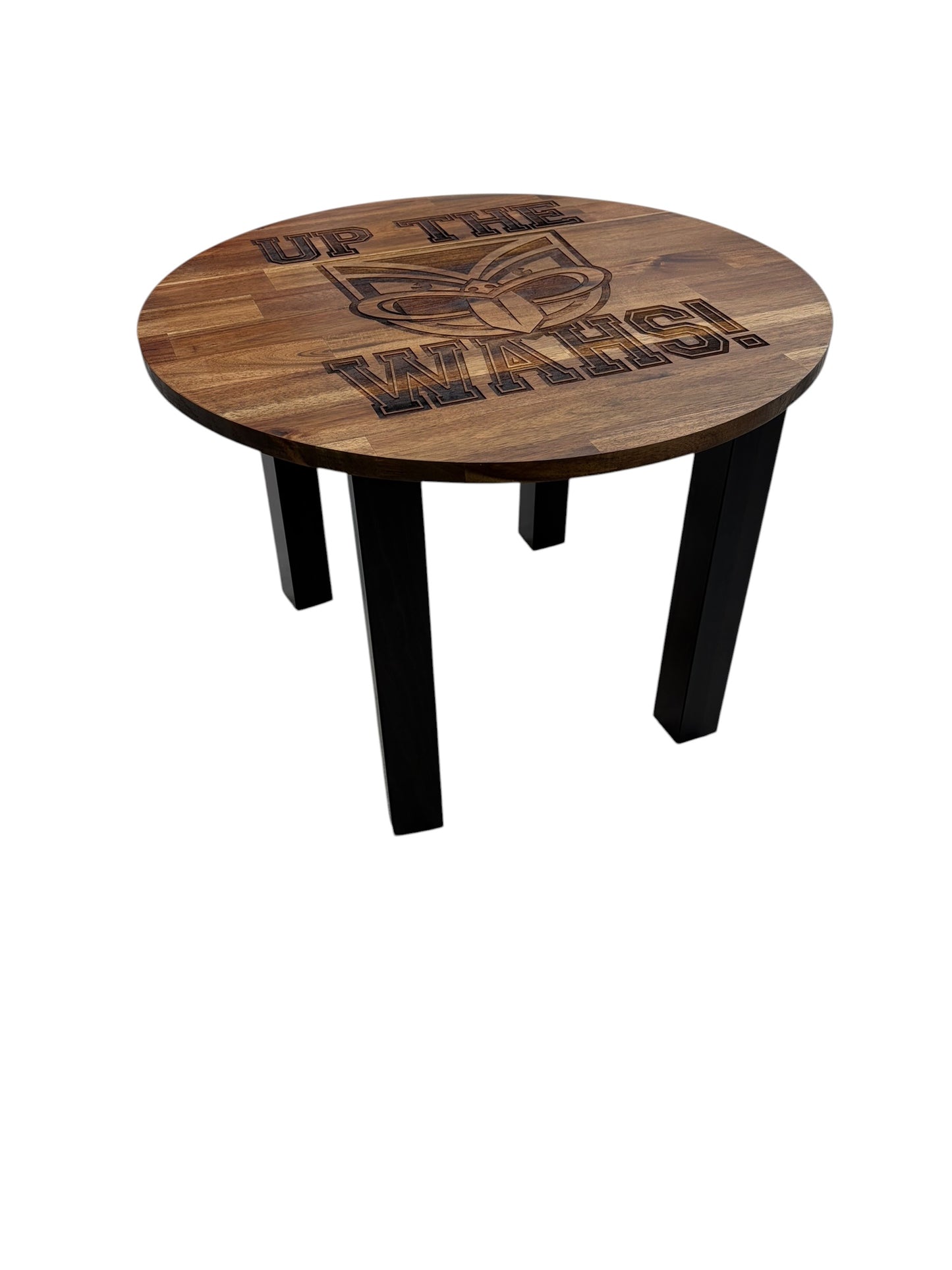 A round wooden table with black legs, featuring a dark engraved logo and the text 'UP THE WAHS!'.